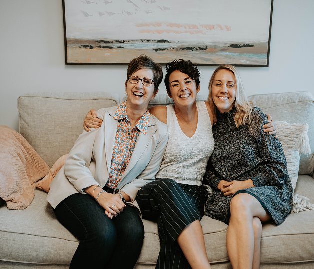 The Willow Tree team sitting together on the office sofa, laughing.
