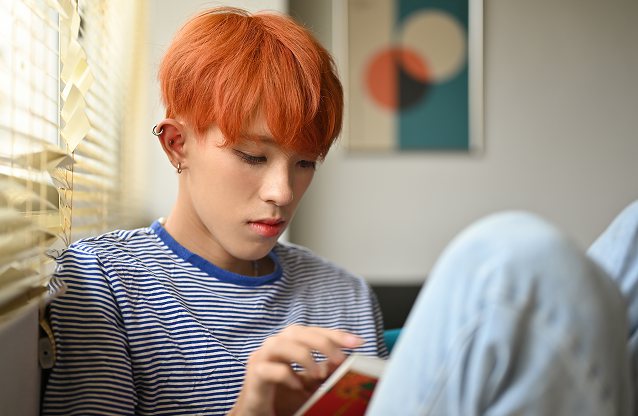 A teenager sitting comfortably, looking towards the camera.